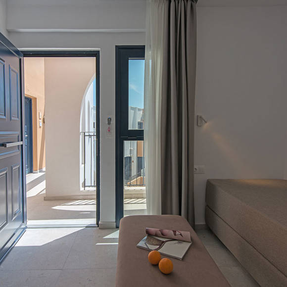 Nami Hotel Suites Suite living room with a big couch, a smaller one as a table and outside view