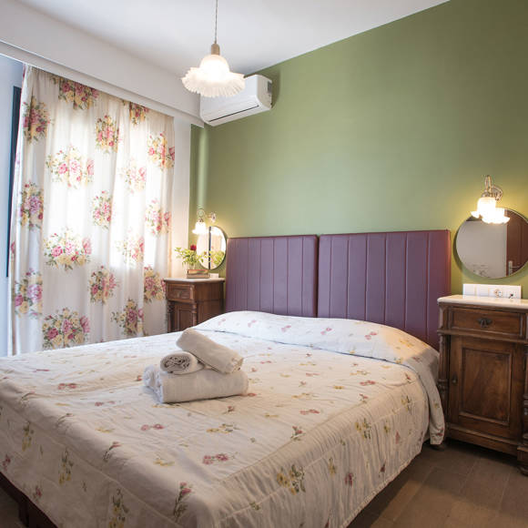 Nami Hotel Suites Artist Room decorated double bed and bedside tables