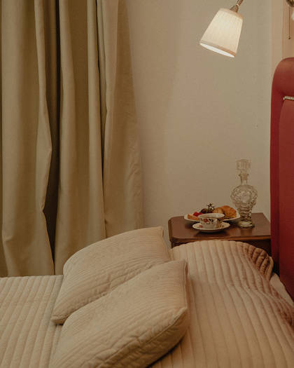 Nami Hotel Suites Artist Room decorated double bed and bedside table