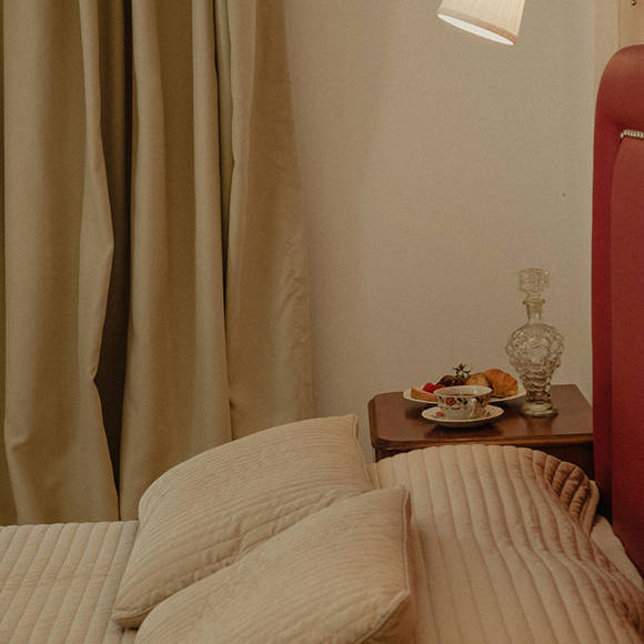 Nami Hotel Suites Artist Room decorated double bed and bedside table