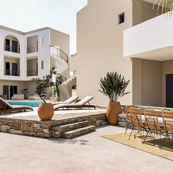 Nami Hotel Suites pool with sunbeds and a big wooden table with chairs