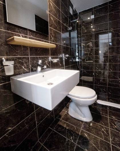 Nami Hotel Suites Artist Room bathroom with black marble wall and floor