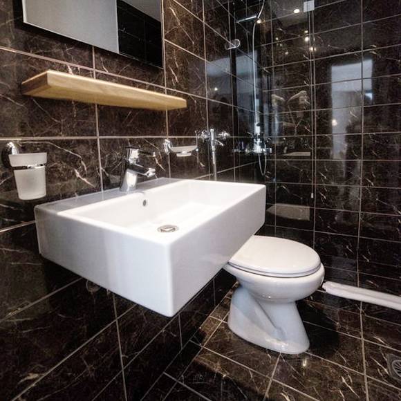 Nami Hotel Suites Artist Room bathroom with black marble wall and floor