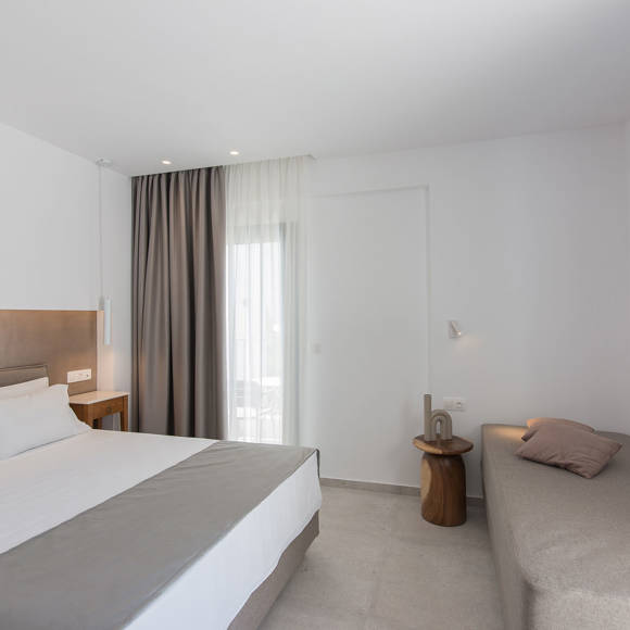 Nami Hotel Suites Deluxe Room double bed, couch and wall mounted television