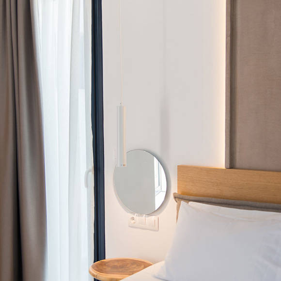 Nami Hotel Suites Deluxe Room small bedside table and round mirror